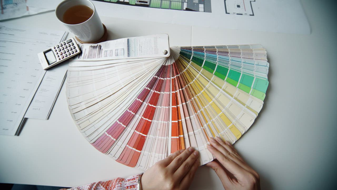 Designer laying out paint and finish swatches beside kitchen drawings